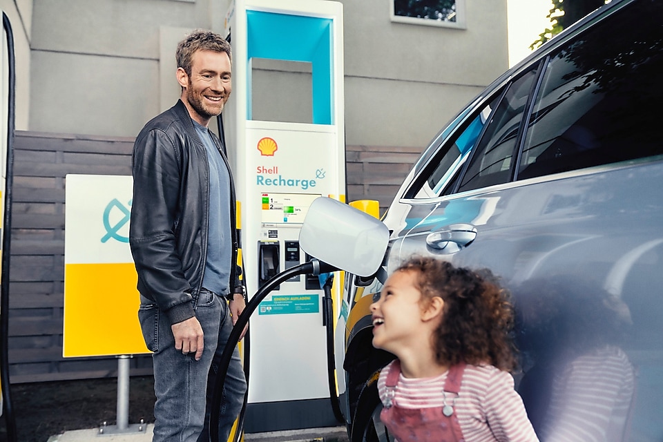 Man filling up electric vehicle with Shell Recharge