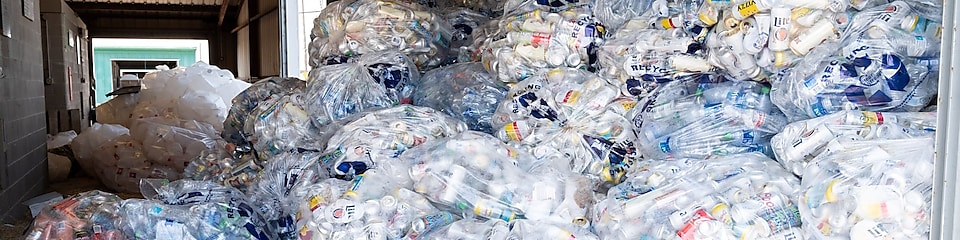 A heaping pile of plastic bags filled with aluminum cans to be recycled